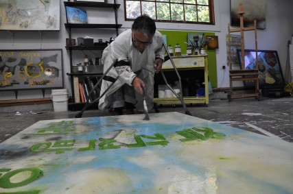 Sam Roloff sitting on the floor of Flotoma Studios Sam Roloff painting in Flotoma Studios